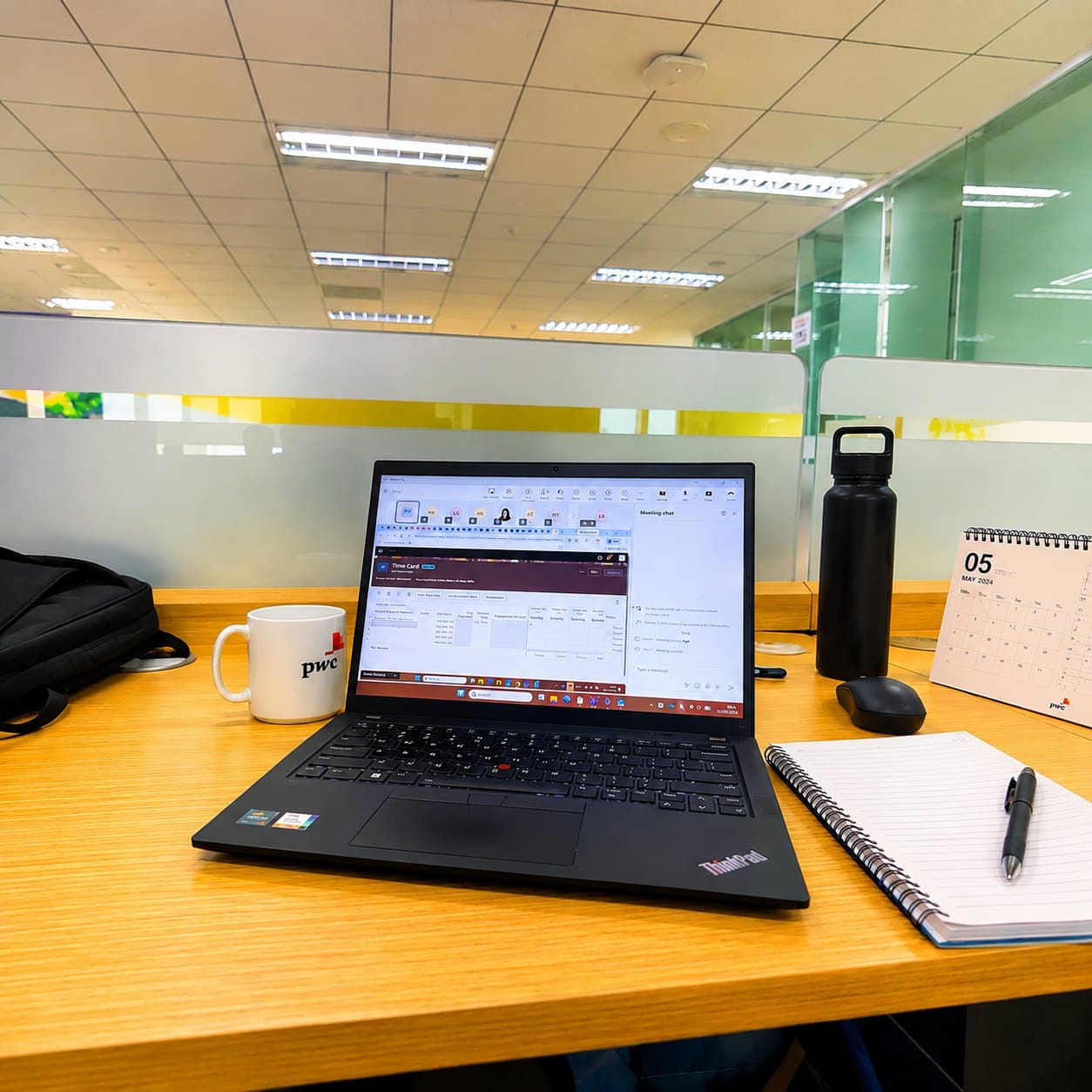 PwC work desk with ThinkPad laptop and PwC mug